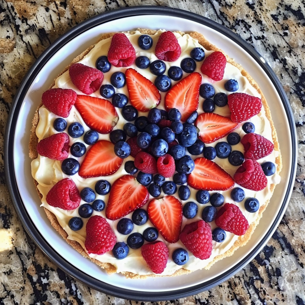 Indulge in our vibrant Berry Bliss Pizza, bursting with goodness and artfully arranged for a feast for your eyes and palate. This colorful fruit tart features sliced strawberries, raspberries, and blueberries atop a creamy filling, all resting on an eco-friendly white plate. Fresh from the granite countertop of Zestful Blends' kitchen, this delightful dessert is not only a visual masterpiece but also rich in health benefits. Perfectly crafted to bring you the freshest flavors and nutrients! Indulge in our vibrant Berry Bliss Pizza, bursting with goodness and artfully arranged for a feast for your eyes and palate. This colorful fruit tart features sliced strawberries, raspberries, and blueberries atop a creamy filling, all resting on an eco-friendly white plate. Fresh from the granite countertop of Zestful Blends' kitchen, this delightful dessert is not only a visual masterpiece but also rich in health benefits. Perfectly crafted to bring you the freshest flavors and nutrients!
